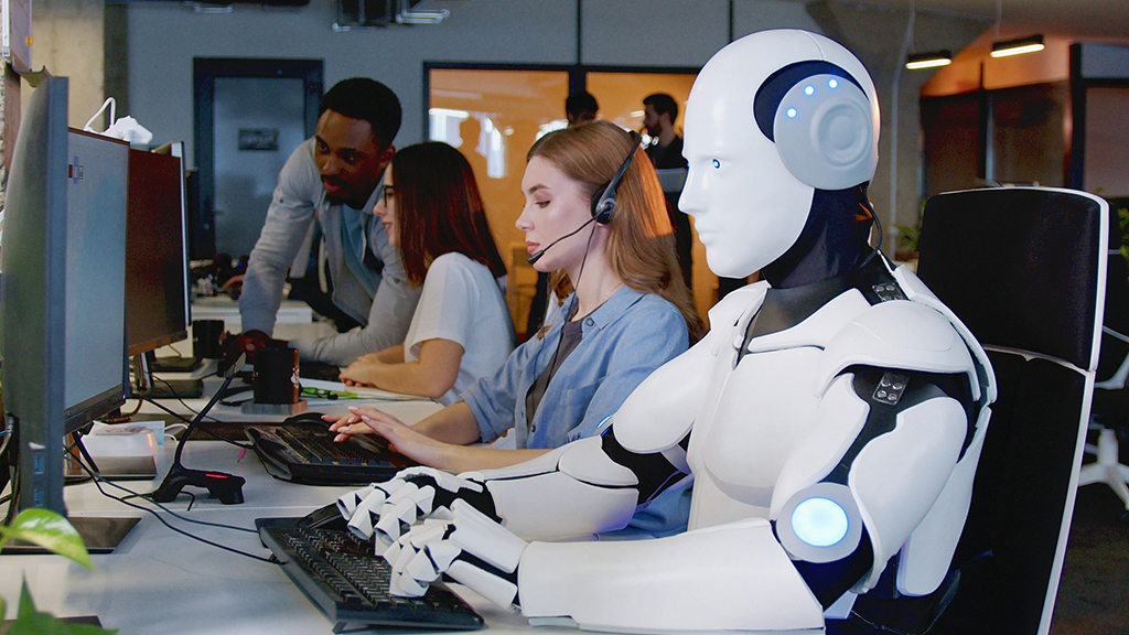 Robot werkt op de computer tussen mensen. Machine typen op toetsenbord in kantoor. IT-team van de toekomst.