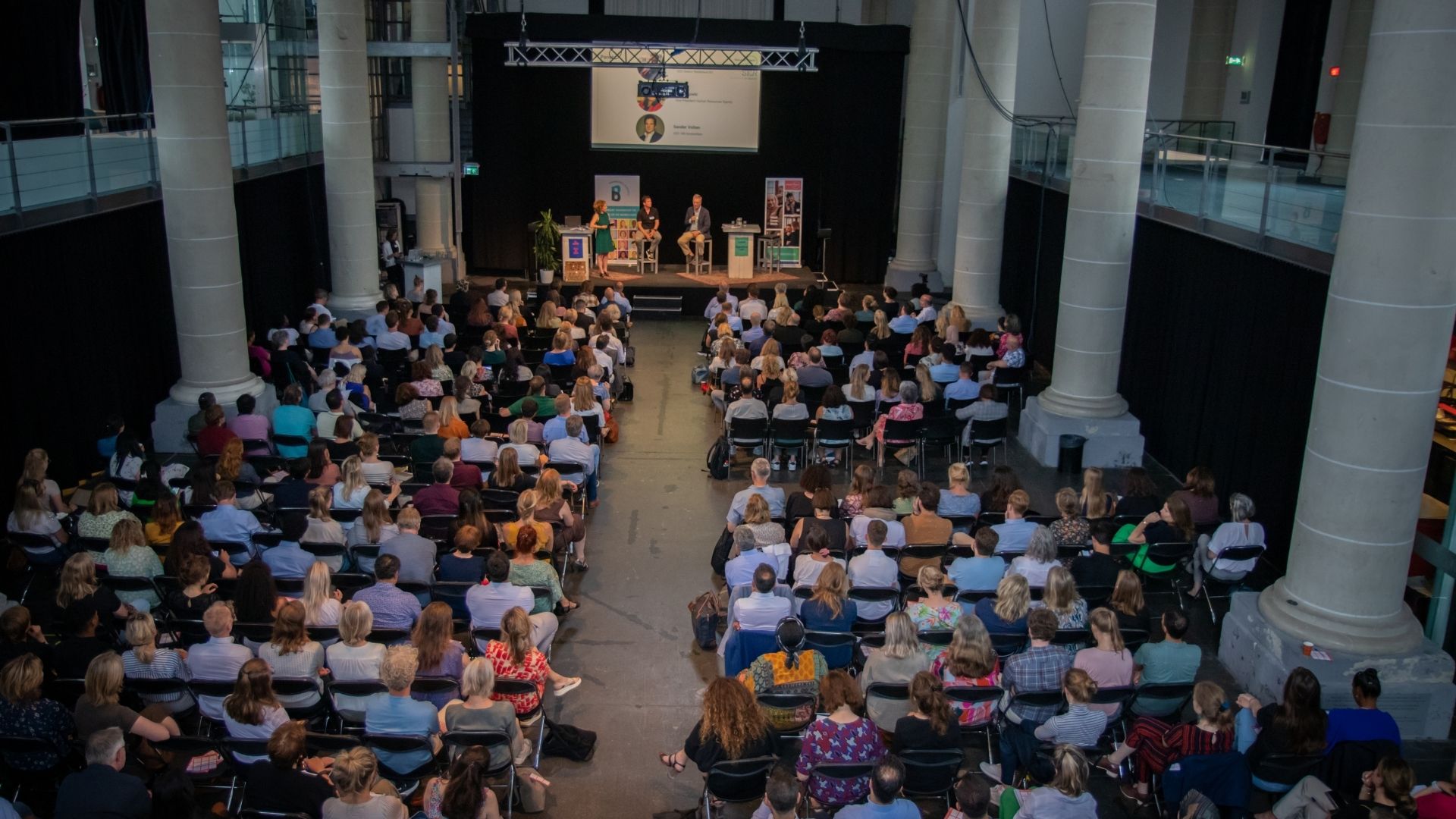 Overzicht publiek in de Zuiderkerk, charterbijeenkomst Statushouders aan het werk