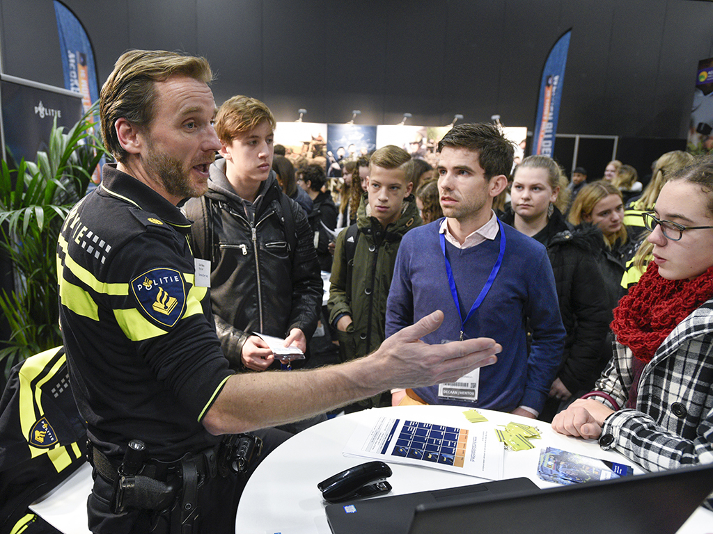 Politieman in gesprek met jonge mensen (voorlichting)