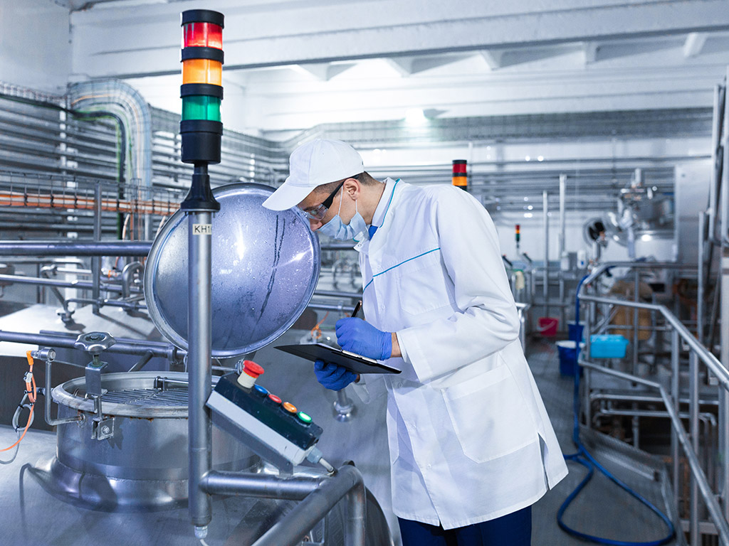 Man in witte jas in chemische fabriek