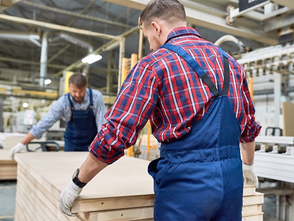 Mannen tillen houten planken op een werkplaats