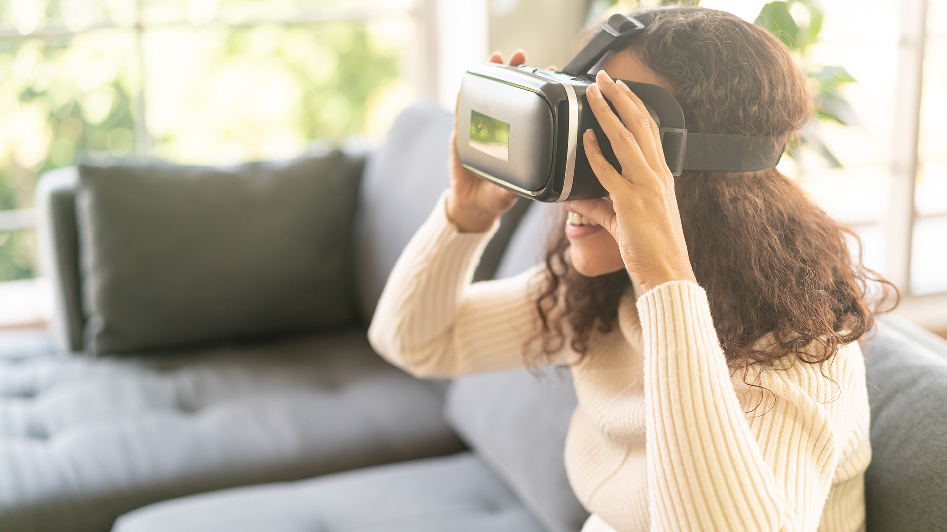 Vrouw die thuis een virtual reality-headset op de bank gebruikt