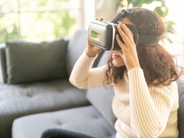 Vrouw die thuis een virtual reality-headset op de bank gebruikt