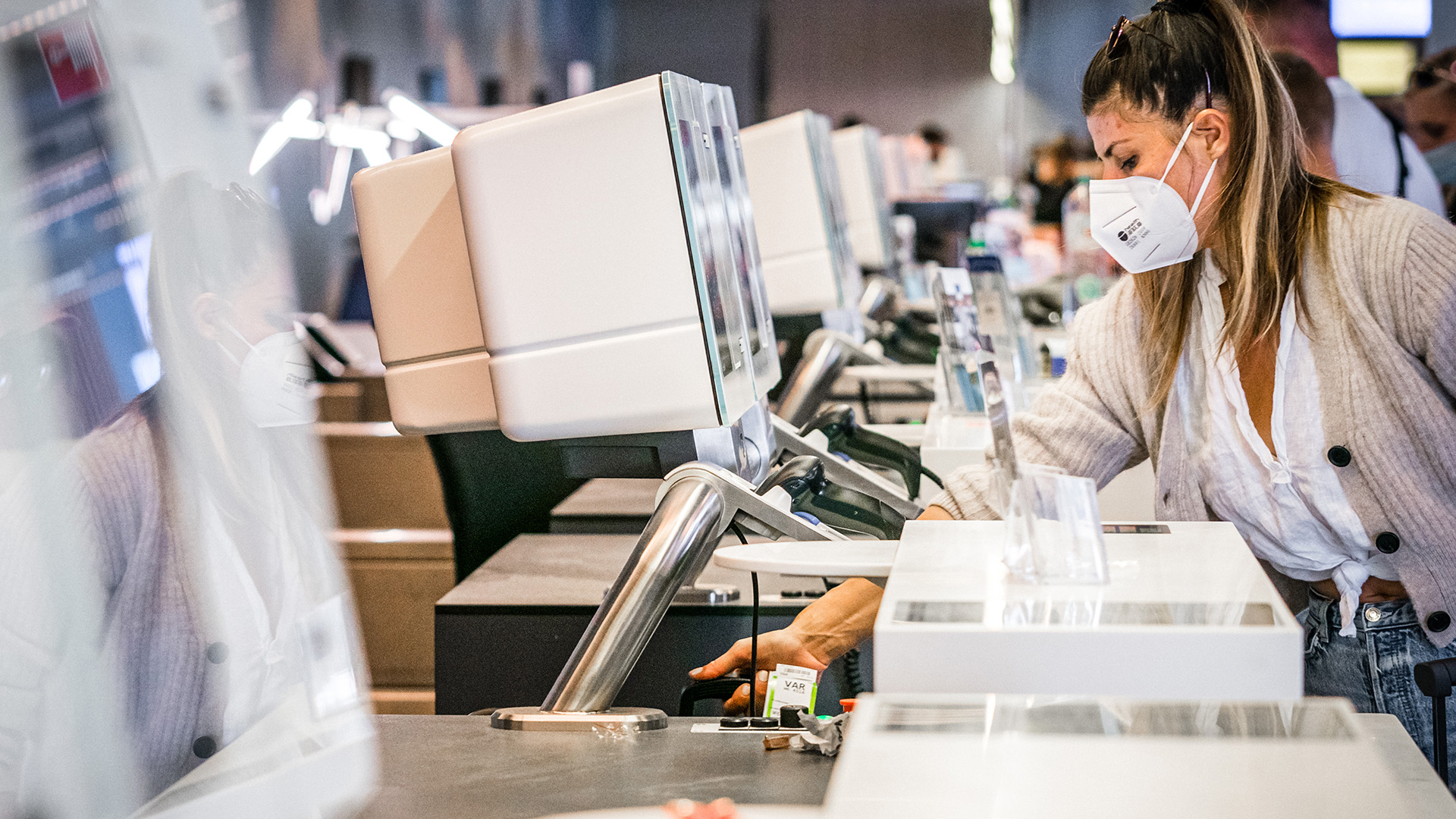 Reizigers checken zelf hun bagage in op Eindhoven Airport.