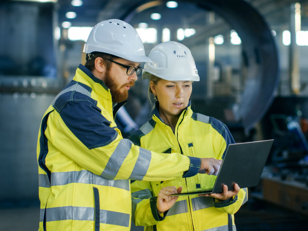 Ingenieurs met veiligheidshelm en laptop