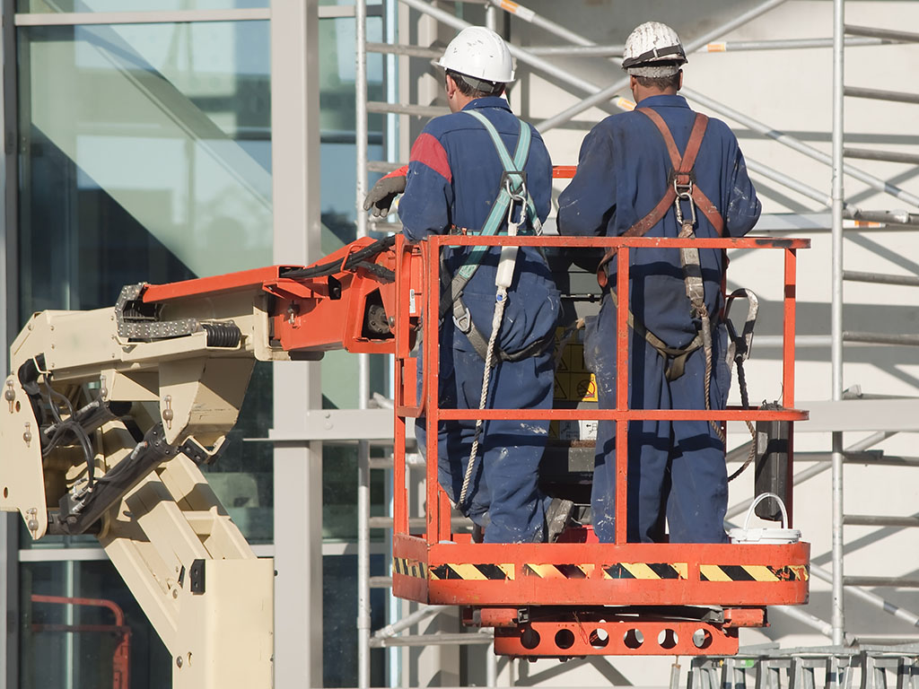 Werknemers dragen veiligheidsharnassen op een hoogwerker