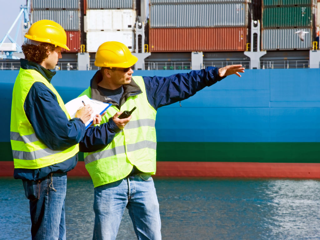 Twee mannen praten in een containerhaven