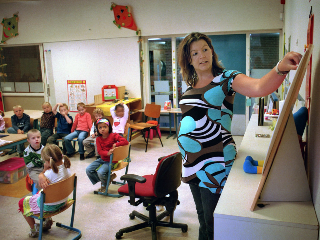 Zwangere docent geeft les op basisschool