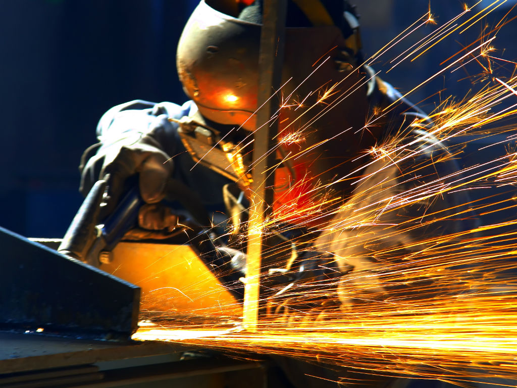 Fabrieksmedewerker slijpt metaal