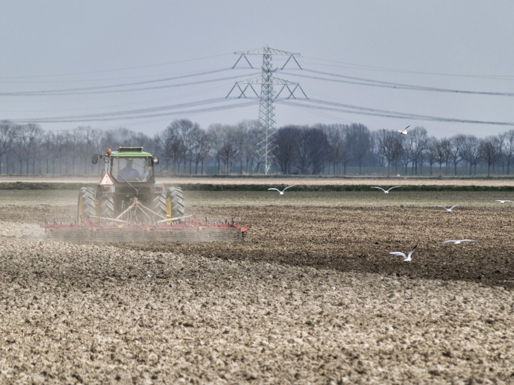 Tractor rijdt op een stoffig veld