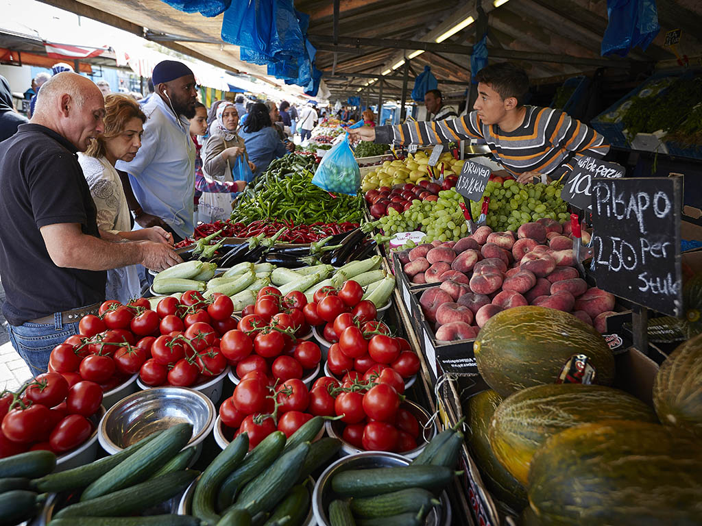 Klanten en verkoper bij een marktkraam