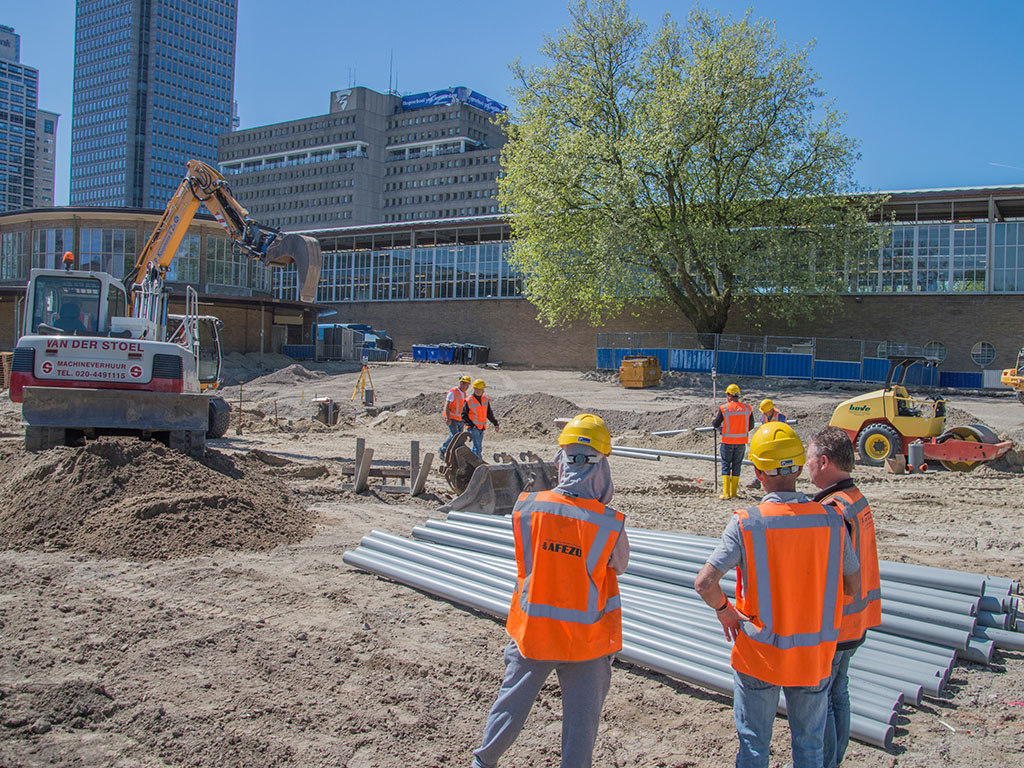 Werknemers, met veiligheidshesje en veiligheidshelm op een bouwplaats