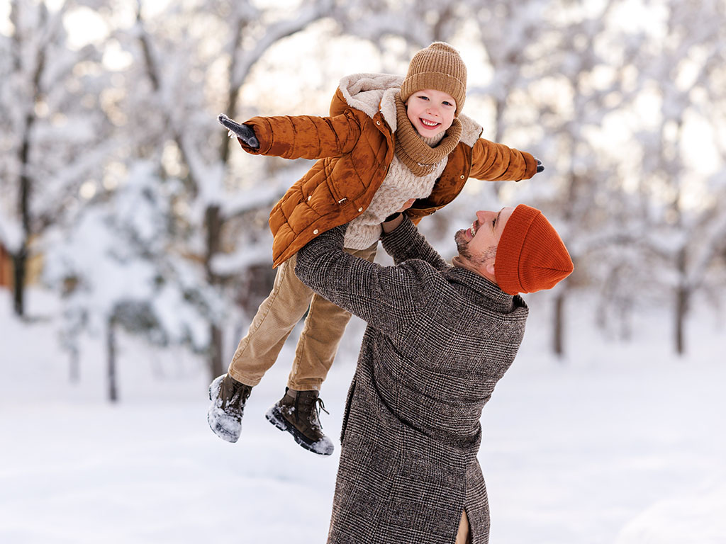 Man houdt een kind in de lucht vast