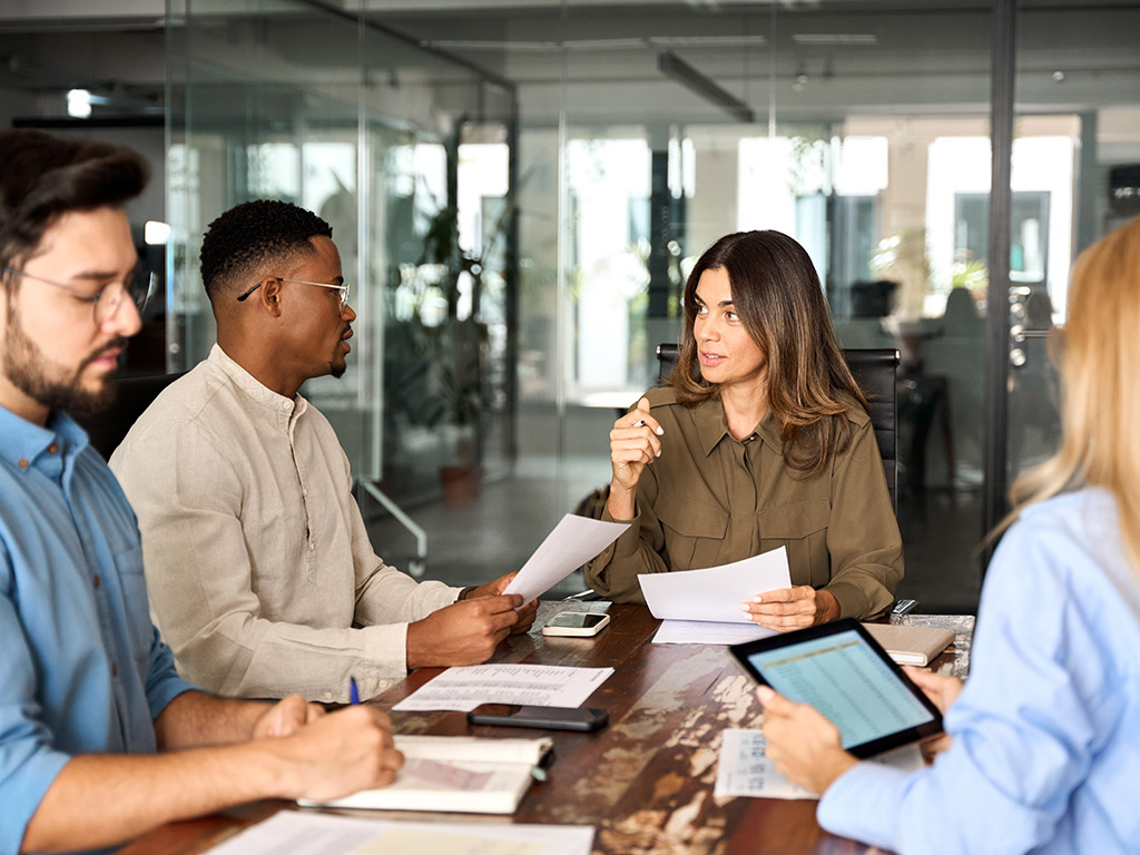 Diverse mensen in overleg aan een vergadertafel